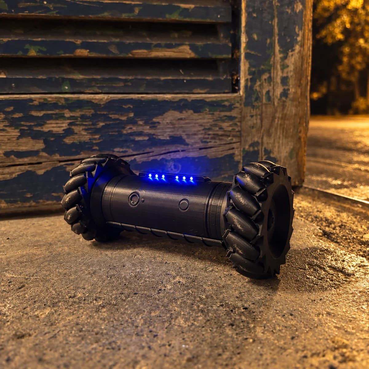 RCD-01 Rainbow Six Siege recon drone replica at night outside an old shuttered building, its blue LEDs lit